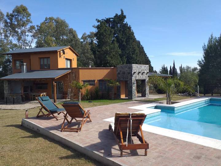 Pileta con reposeras frente a la casa